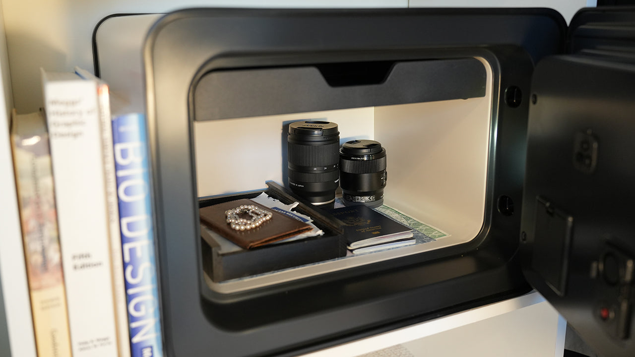 The interior of a small fire resistant safe: Cocono 20 small in home safe with passports, checkbook, pearls, and camera lenses inside.