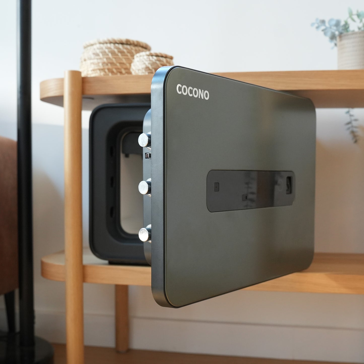 Olive green Cocono 20 small fire resistant safe on a shelf.